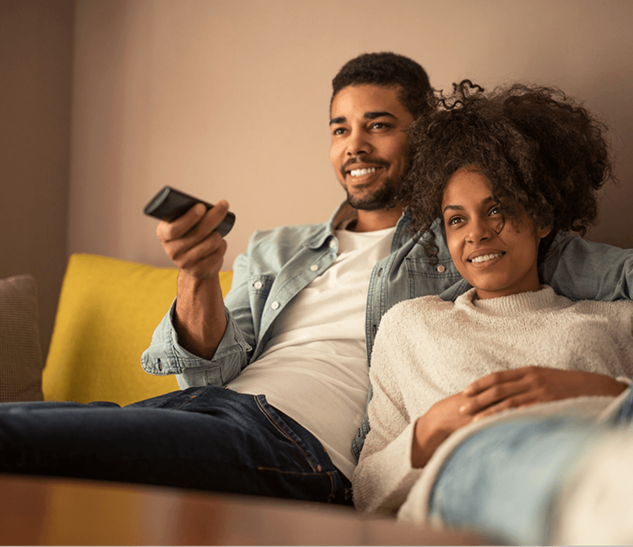 A couple relaxing on a sofa watching TV together